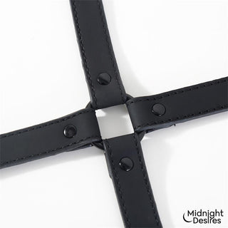 Svarta hogtie-remmar i veganskt läder med metallnitar, avbildade mot en vit bakgrund.