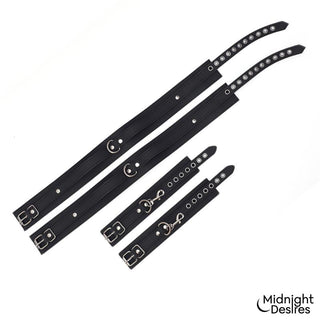 Set med fyra svarta, justerbara manschetter i veganskt läder med detaljer i metall. Midnight Desires Bondageset-logotyp i hörnet.