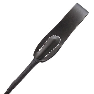 Närbild av Latetobed Riding Crop 66 cm, med svart läder och vita sömmar på paddeln - perfekt för BDSM dominanslekar.