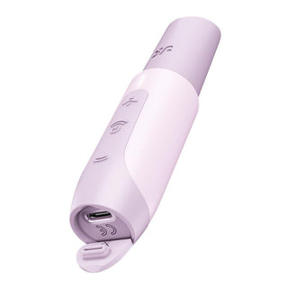 Satisfyer Secret Kiss är en pastelllila och vit cylindrisk enhet med en böjd design. Den har knappar, symboler och en USB-laddningsport täckt av en liten lucka. Denna vattentäta gadget säkerställer hållbarhet i våta förhållanden.