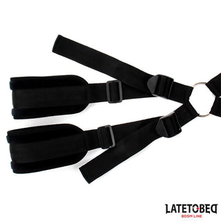 Latetobed Shoulder Swingstrap har svarta justerbara fasthållningsanordningar med vadderade manschetter och remmar, förbundna med en metallring. Latetobed-logotypen visas i hörnet.