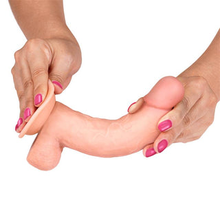 En person med rosa naglar håller i Slidy Realistisk Dildo och visar upp dess skjutbara hud-design.