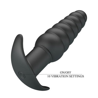 Svart analplugg i mjuk silikon med räfflad design, utsvängd bas och tio vibrationslägen.
