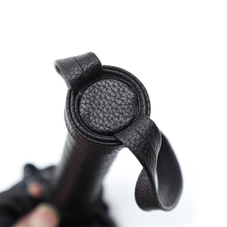 Närbild av det svarta texturerade läderhandtaget med två remmar som är slingrade runt toppen, vilket liknar ett ergonomiskt grepp som det på Latetobed Classic Flogger 42cm.