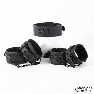 Svart bondagehalsband i veganskt läder med metallspännen och kedjelänkar, avbildat mot en vit bakgrund.