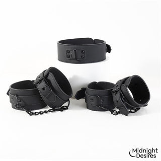 Svart bondagehalsband i veganskt läder med metallspännen och kedjelänkar, avbildat mot en vit bakgrund.