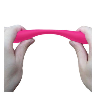Två händer sträcker ut en ljusrosa, flexibel PrettyLove Yedda Bendable-vibrator mot en vit bakgrund, vilket framhäver dess C-form som är utformad för både klitoris- och G-punktsstimulering.