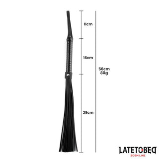 Latetobed Flogger 52 cm har ett handtag, upphängningsögla och tofsar för varierad stimulering. Mått och vikt visas vid sidan av produkten.