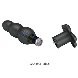 Svart analplugg i silikon med vibrationsfunktion, plats för AAA-batteri och avtagbart lås mot vit bakgrund.