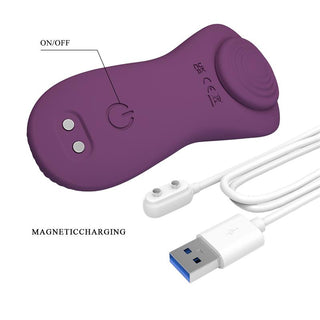 Trosvibrator i lila silikon med på/av-knapp, magnetisk laddningsport och medföljande USB-laddningskabel.