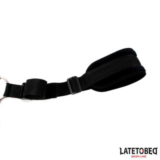 Latetobed Shoulder Swingstrap, en svart justerbar BDSM-fasthållningsmanschett med ring, visas på en vit bakgrund.