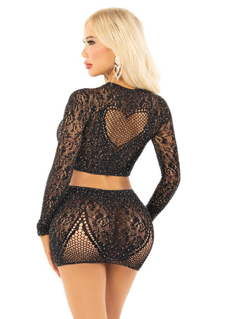 Set bestående av en svart crop top med strass och en minikjol, med genomskinliga spetsdetaljer och ett hjärtformigt hål på ryggen.
