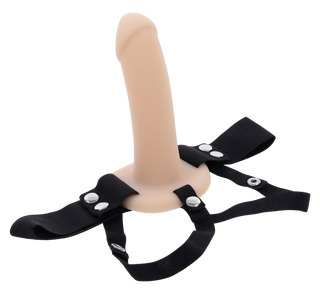 Strap-on i beige silikon med ihåligt skaft, justerbar sele och metallknäppen, visas mot en vit bakgrund.