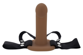 Hollow Strap-On Dildo 16 cm är en brun ihålig dildo med svarta justerbara remmar och silverfärgade tryckknappar, visad mot en vit bakgrund.