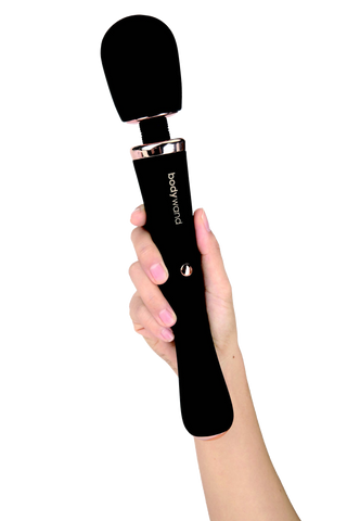En hand som håller i en svart Bodywand Couture Magic Wand silikonskal trollstav-vibrator med varumärket "bodywand" på handtaget.