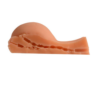 Mature Kelly Masturbator är en liten, abstrakt rosa skulptur med en slät, långsträckt bas och en kurvig design på toppen, mot en vit bakgrund.