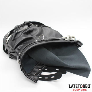 Total Lockdown BDSM Mask, tillverkad av svart läder med remmar och spännen, är delvis uppknäppt och visas på en vit bakgrund.