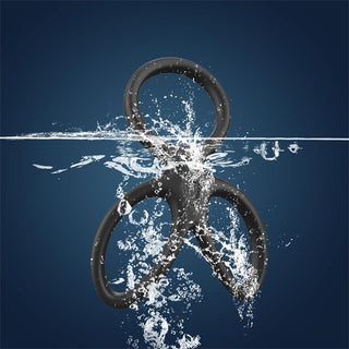 En svart ampersandsymbol, som påminner om den eleganta Beast Rings Triple Penisring, skvätter genom vatten mot en mörkblå bakgrund.