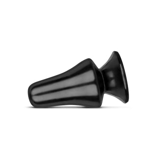 Bred Svart Buttplug 12 cm, en slät svart konformad plugg med utsvängd bas, tillverkad av kroppssäker, ftalatfri PVC, ligger på sidan mot en vit bakgrund.