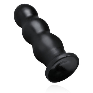 XXL Ribbad Buttplug från BUTTR, ett svart konturformigt cylindriskt silikonobjekt med en räfflad design på en rund bas, vilar på en vit bakgrund och lovar intensiv stimulering.
