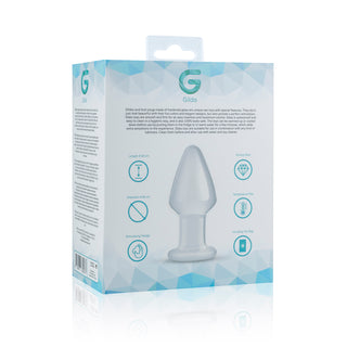 Gildo Glass Buttplug 4,6 cm levereras i en förpackning, tillverkad av temperaturkänsligt borosilikatglas, med produktinformation, diagram och ikoner på en vit och blå geometrisk bakgrund.