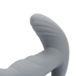 Närbild av det gråa, strukturerade handtaget med en böjd ände gjord av kroppssäker silikon, som framhäver designen av den roterande prostatastimulatorn mot en vanlig vit bakgrund.