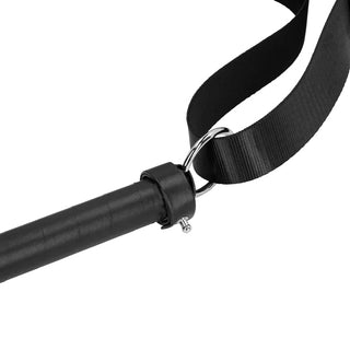 Närbild på en svart rem fäst vid ett svart handtag med metallring och klämma, perfekt att lägga till i din BDSM-selekollektion för dominanslekar.