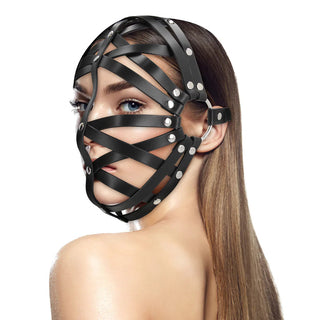 Kvinna med rakt brunt hår bär "Lädermask med Remmar", en BDSM-harneskmask i svart läder som täcker större delen av ansiktet.