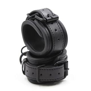 Svarta handbojor i läderimitation med metallspännen, visas staplade på varandra, utformade för säker och justerbar fastsättning.