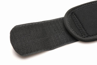 Närbild av Thigh Strap-On-selen, med en justerbar svart tygrem med kardborreknäppning, fäst vid en vadderad sektion gjord av fuktabsorberande material.