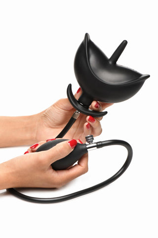 Händer med röda naglar håller en elegant enhet som liknar XR Brands Uppblåsbar Buttplug, med en svart uppblåsbar glödlampa.