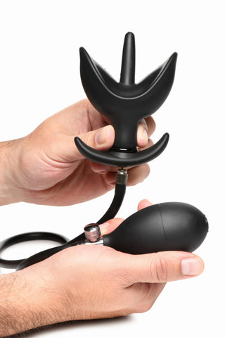 Händer som håller XR Brands Uppblåsbar Buttplug, en uppblåsbar analplugg av silikon med en bulbpump och vingar, isolerad på en vit bakgrund.