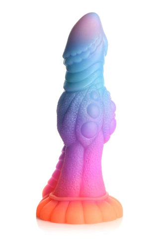 Glow-In-The-Dark Alien Dildo är en färgstark, strukturerad fantasyskulptur tillverkad av ftalatfri silikon, med en blå-till-rosa gradient ovanpå en orange bas med en sugkopp för säker placering.