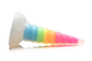 XR Brands Unicorn Horn Dildo är en levande, genomskinlig leksak formad som ett enhörningshorn, gjord av flexibel silikon med en regnbågsgradient och lyser i mörkret mot en vit bakgrund.