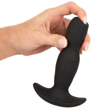 En hand håller Anos Finest Buttplug Med Fjärr, med en elegant svart design med en utsvängd bas, tillverkad av högkvalitativt silikon för optimal komfort och hållbarhet.
