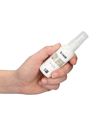 En hand håller en liten vit sprayflaska märkt Sono, möjligen idealisk för den som är intresserad av att använda Milt bedövande analgel - 50 ml.