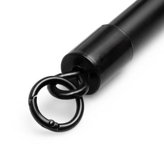 En närbild av "Hogtie i Metall Med Bojor", som visar sin eleganta svarta cylindriska design och cirkulära krok, mot en orörd vit bakgrund.