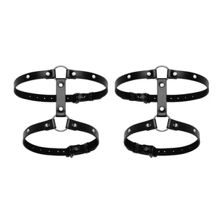 Bedroom Fantasies Lår Harness, tillverkad av svart PU-läder med metallringar och justerbara remmar, skapar en fantastisk display mot en vit bakgrund, perfekt för att utforska sovrumsfantasier.