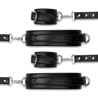 Cuffs & Hogtie-setet har svarta läderskydd, spännen och metallringar anordnade horisontellt på en vit bakgrund. Dessa justerbara justerbara manschetter lägger till spänning till intima stunder.