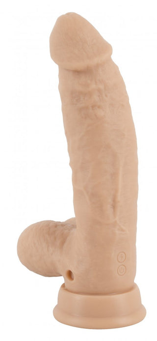 Realistixxx Torero Dildo, designad med realistiska hudtonade detaljer och en robust sugbas, står upprätt mot en vanlig vit bakgrund och erbjuder flera vibrationslägen för en förbättrad upplevelse.