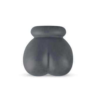 En grå, abstrakt, kurvig skulptur tillverkad av mjuk flexibel silikon, med en slät yta mot en vit bakgrund, liknar Boners Silikon Ballstretcher.