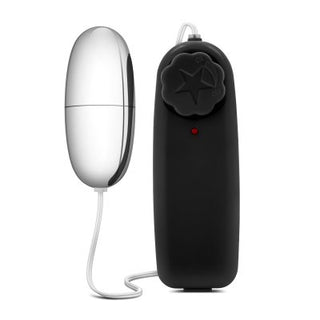 En elegant silver, äggformad "Vibrerande Ägg Med Fjärrkontroll" är ansluten med en tråd till en svart fjärrkontroll med en intuitiv urtavla.