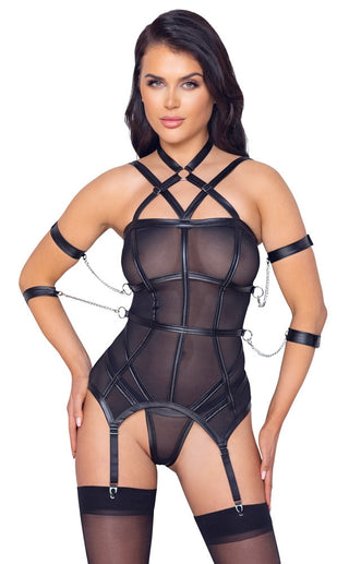 En person i en Bustier Med Strumphållare & Trosa med svarta mesh- och läderremmar med kedjedetaljer, iförda strumpor och koordinerande strumphållare.