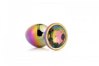 Multifärgad Buttplug Kristall - Liten har en metallisk, regnbågsfärgad design med en facetterad ädelstensliknande bas och visas elegant på en vit bakgrund.