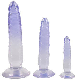 Tre gradientlila silikondildos i olika storlekar, designade för anal njutning, står stabilt på sin robusta sugkoppsbaser i You2Toys Crystal Clear Dildo Set.