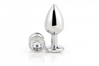 Gleaming Love Silver Plug Large, tillverkad av högkvalitativt aluminiummaterial, visar två glänsande metallpluggar – en upprätt och en på sidan – var och en med en juvelliknande ände, vilket säkerställer anal njutning.