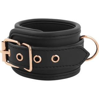Coquette Fantasy Fotbojor är en handledsmanschett i läder med justerbar design, roséguldspänne och D-ringdetaljer, som förkroppsligar elegant bondage-estetik.