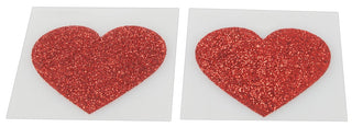 Två röda glitter hjärtformade nippel klistermärken på vita fyrkantiga bakgrunder.