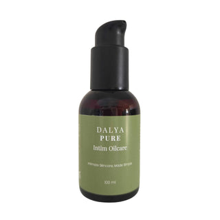 Mörkfärgad pumpflaska i plast med etiketten Dalya Pure Intim Oilcare 100 ml mot grön bakgrund.