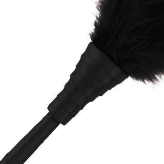 Det delvis synliga Darkness - Fjäder, med sitt svarta läderhandtag, tillför ett element av mystik till ditt förspel.